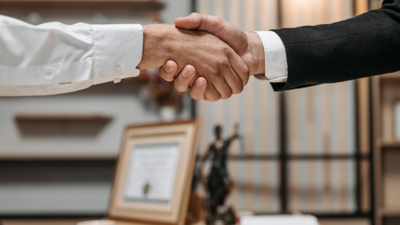 Close-up of a handshake between two professionals in a modern office setting, emphasizing partnership and agreement., tags: neue anwalt zürich - pexel